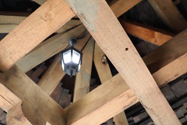 Güzel, ahşap bir tavan yapısı klasik bir fener ışığı barındırıyor, kırsal zarafeti yakalıyor.