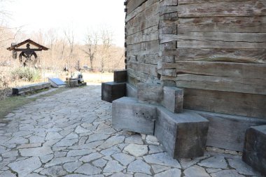 Doğayla mimariyi harmanlayan büyüleyici ahşap bir yapının yanında manzaralı bir taş patika uzanır.