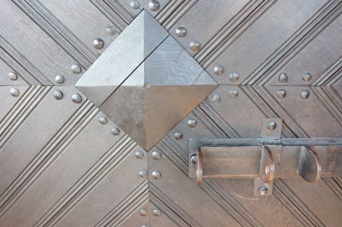 Geometrik desenleri ve dokuları gösteren güzel dekoratif metalik bir kapının yakın çekim görüntüsü