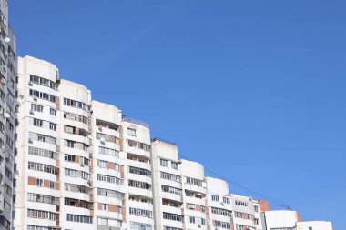 Canlı mavi bir gökyüzü zeminine karşı kurulmuş çağdaş, şık bir apartman kompleksinin nefes kesici manzarası.