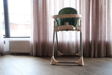 Bebekler için özenle tasarlanmış şık bir sandalye, doğal ışıkla dolu sıcak ve davetkar bir odaya yerleştirilir.