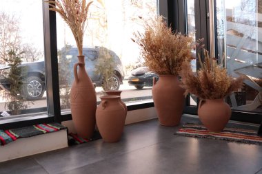 Bu modern iç tasarım modern dekorasyon için mükemmel, kurumuş bitkilerle süslü kil vazoları içerir.