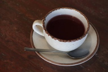 Rahatlatıcı bir fincan sıcak bitkisel çayın tadını çıkarıyorum. Bol çikolatalı bir kenarla süslenmiş. Sıcak, rahatlatıcı bir akşam için ideal.