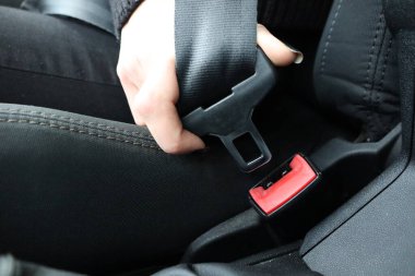 Araba kullanırken emniyet kemerini takan bir kişinin yakın plan fotoğrafı.