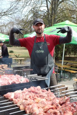 21.03.2025 Chisinau hevesli bir şef bu hafta sonu canlı ve canlı bir açık hava barbekü etkinliğinde lezzetli bir et pişiriyor.