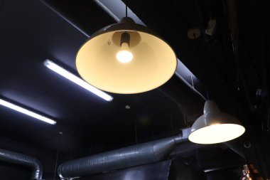 Modern bir ortamda zarif endüstriyel lambalar asılı, tasarım için mükemmel.