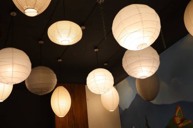 Hoş estetik kağıt fenerler zarifçe asılır, sıcak ve davetkar bir atmosfer yaratır kapalı mekanlarda