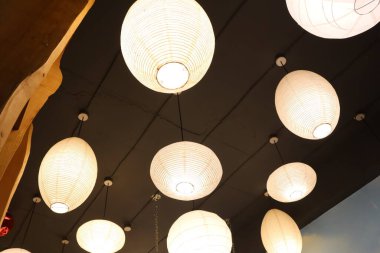 Güzel tasarlanmış kolye fenerleri modern iç mekanlarda sıcak ve davetkar bir ortam yaratıyor.