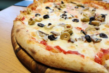 Zeytin, peynir ve taze malzemelerle süslenmiş lezzetli bir pizza. Her yerde yemek severler için mükemmel.