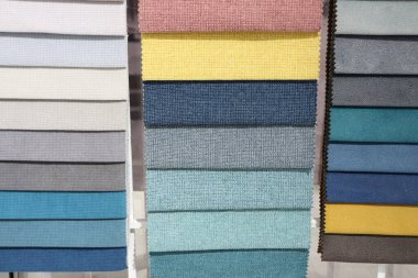 Geniş bir kumaş örneği dizisi yaratıcı bir şekilde canlı renkler ve tasarım ilhamı için çeşitli dokular sergiliyor.