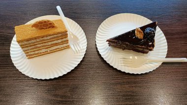 Lezzetli pasta katmanlarının ve tüm tatlı aşıkları için beyaz tabakta servis edilen zengin çikolataların tadını çıkarın.