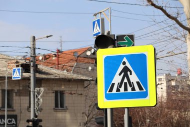 Şehir ortamında yaya önceliğini açıkça gösteren son derece görünür ve parlak bir yaya geçidi tabelası.