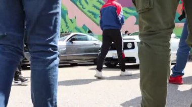 22.04.2025 Moldova Canlı bir araba meraklıları topluluğu Renkli bir arkaplan karşısında çarpıcı klasik Mustangleri gururla sergiliyor