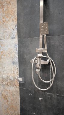 Bu şık duş sistemi, duvarlara monte edilmiş bir duş başlığı ve elverişli bir duşu olan modern bir tasarıma sahip.
