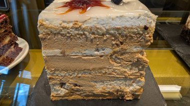 Çekici bir katmanlı pasta, kremalı dolgu ve güzel malzemeler, mutfak sanatını gözler önüne seriyor..