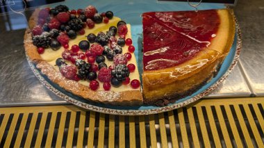 Parlak bir jöleyle süslenmiş bir dizi canlı böğürtlen içeren gerçekten cazip bir cheesecake.