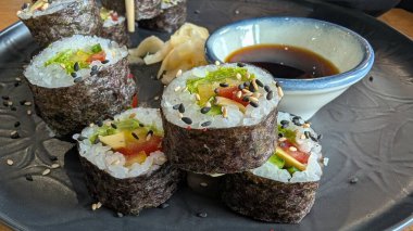 Soya sosu ve turşulu zencefil ile servis edilen canlı bir suşi tabağı, her durum için mükemmel..