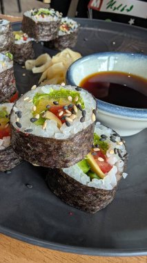 Taze hazırlanmış suşi ruloları, soya sosu ve süslerle birlikte çok güzel sunuluyor. Yemek meraklıları için ideal.