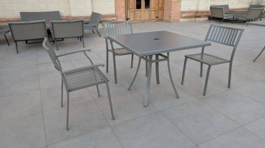 Bu açık hava yemek seti modern kare bir masa ve metal sandalyeler içeriyor. Açık alanları rahatlatmak için birebir.