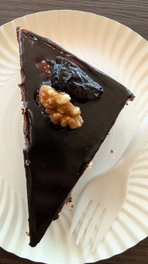 Çok zengin bir çikolatalı pastanın tadını çıkarın. Üstü çıtır çıtır fındıklarla kaplı ve parlak bir jöleyle bitirin.