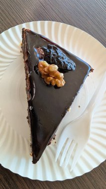 Çıtır cevizli ve kuru meyveli zengin bir çikolatalı pastanın tadını çıkarın. Lezzetli bir ikram için mükemmel.