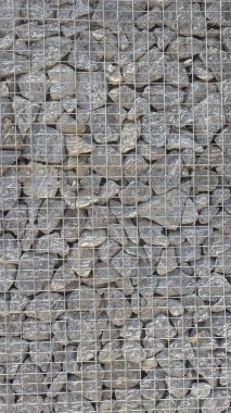 Bir gabion duvarının detaylı yakın plan görüntüsü çeşitli taş kümelerinin tel örgüler içinde sıkıca tutulduğunu gösteriyor.