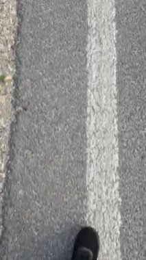 Kaldırımlı bir yolda yankılanan ayak sesleri, büyük açık havada yürüme yolculuğunu vurguluyor.