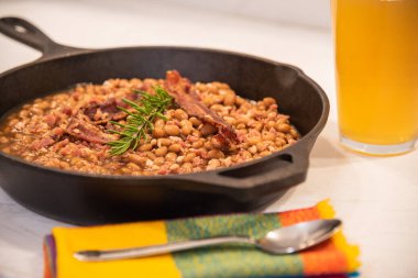 Üstünde domuz pastırması olan fırında fasulye.