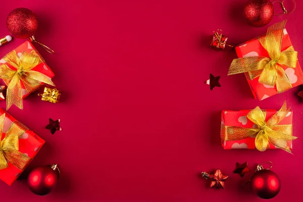 お祝いのメッセージのための部屋が付いている赤い背景の金のリボン弓が付いている赤いペーパーで包まれる休日のギフト用の箱 クリスマスの背景 挨拶カード モックアップ — ストック写真