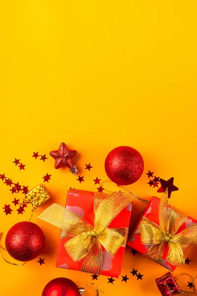 あなたの挨拶のための空の円が付いている黄色い背景の黄金のリボン弓が付いている赤いペーパーで包まれるギフト用の箱が付いているクリスマスおよび新年の構成は モックアップします — ストック写真