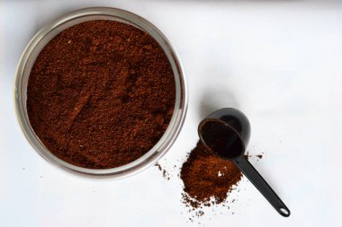 Beyaz arka planda kahve olan cam bir kavanoz.