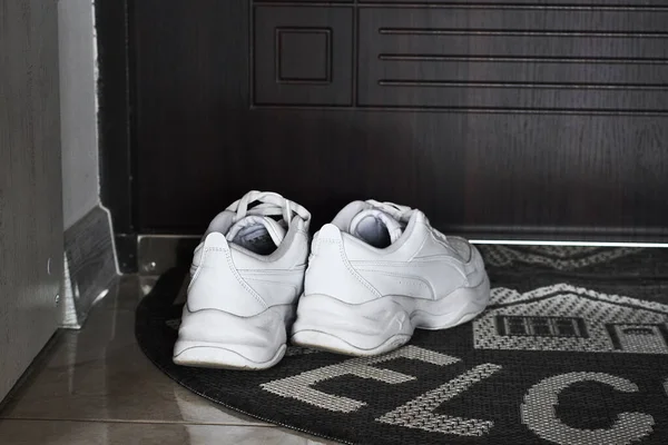 Λευκά Παπούτσια Στο Χαλί Δίπλα Στην Πόρτα — Φωτογραφία Αρχείου