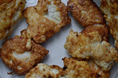 Kızarmış tavuk pirzolası cam bir tabakta yatıyor.