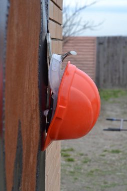Kapı kolunda turuncu bir kask asılı.