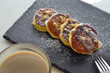 Tatlı peynirli kekler ve kahve kahvaltı için hazırlandı.