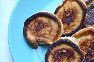 Kızarmış börekler mavi bir tabakta yatıyor