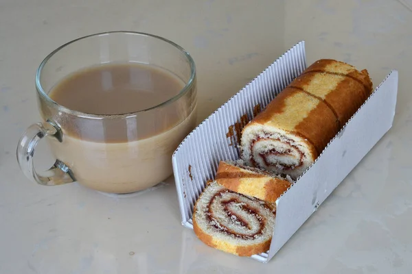 桌上有一个甜面包卷和加奶的咖啡 — 图库照片