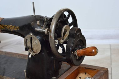 Eski siyah metal dikiş makinesi ahşap bir standın üzerinde