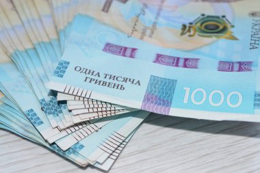 Parlak bir masaya saçılmış para, binlerce Hryvnias