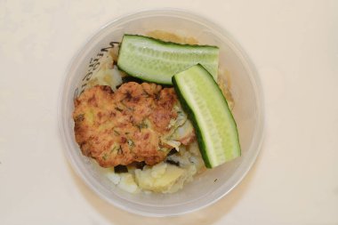 Masanın üzerinde köfte, salatalık ve patates var.