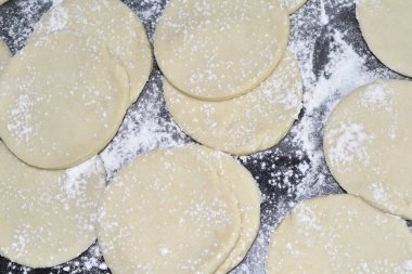 Siyah bir masada hamur işi var.