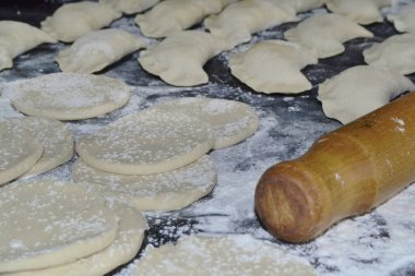 Masanın üzerinde hamur tatlısı ve merdane var.