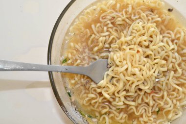 Masanın üzerinde kaynamış vermicelli var.