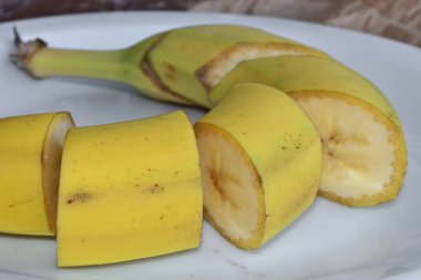 Muz dilimleri mavi bir tabakta duruyor.