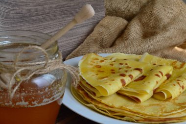 Krepli bir tabak ve karanlık bir masada bir kavanoz bal.
