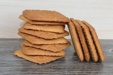 Hafif kurabiyeler, karanlık bir masanın üzerinde üst üste yatar.