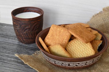 Tabakta hafif kurabiyeler ve bir fincan süt.