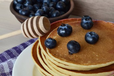 Masanın üzerinde krep tabağı var, böğürtlen ve bal var.