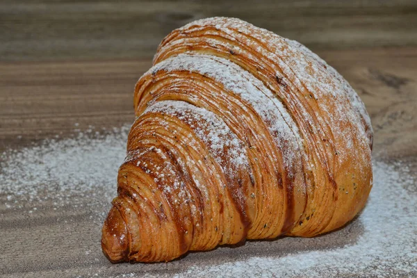 Croissant Mit Puderzucker Bestreut Auf Einem Holztisch — Stockfoto