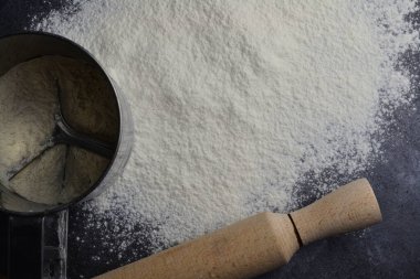 Siyah bir masada ellenmiş un.